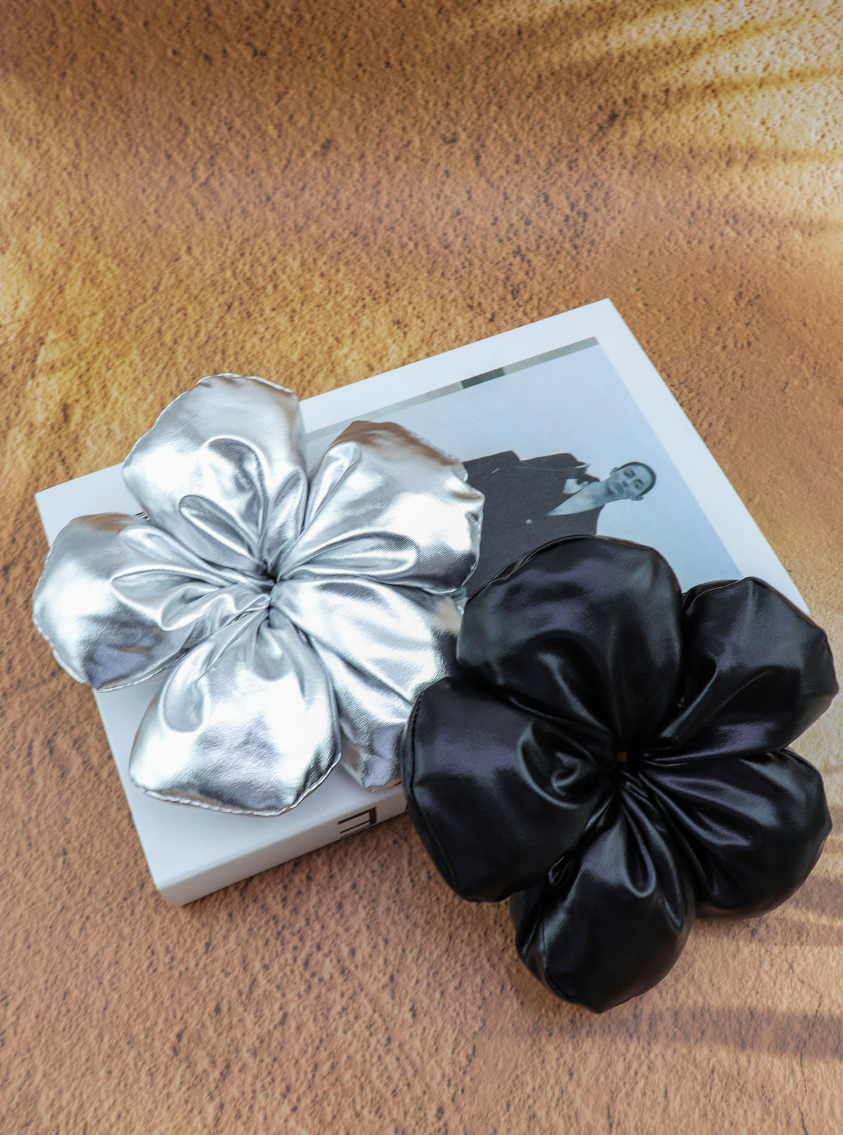Jayva Black and Silver flower scrunchies in a styled setting