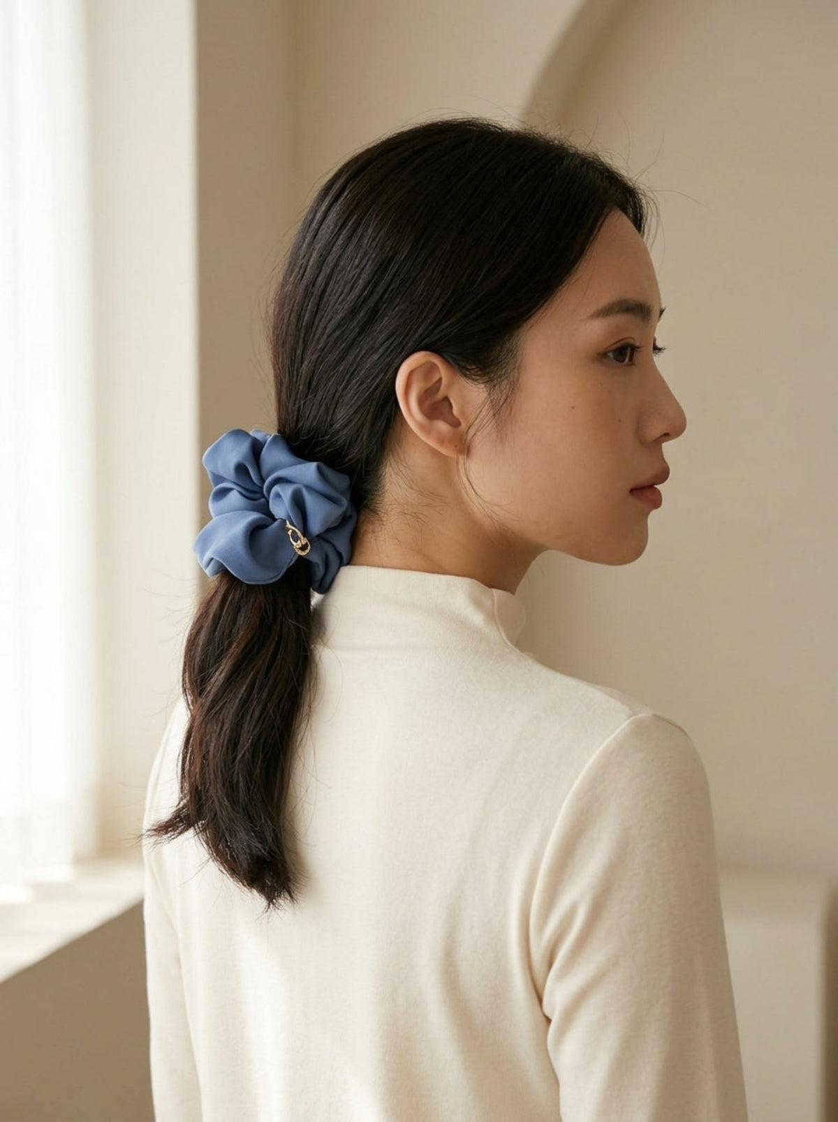 Model wearing Jerika Ocean scrunchy in a low ponytail