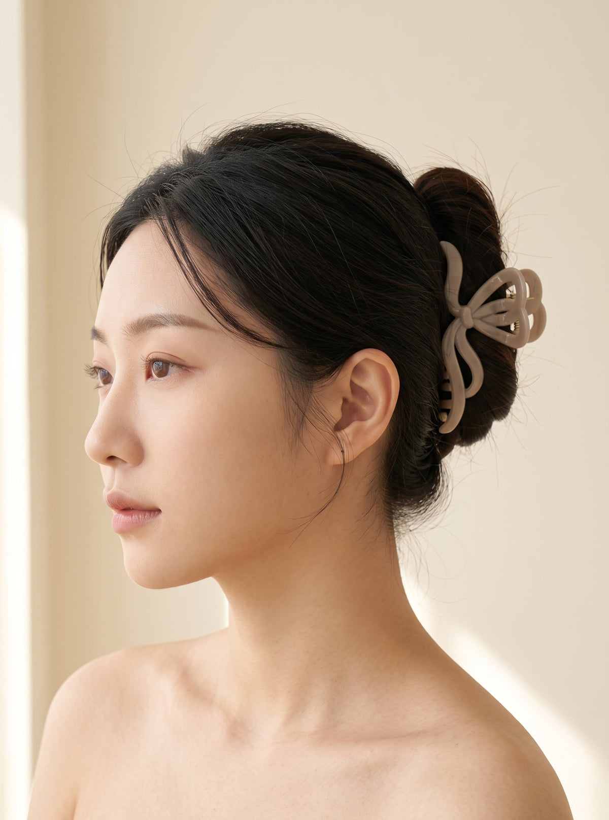 Close-up of Jolanthe beige hair claw worn in an updo