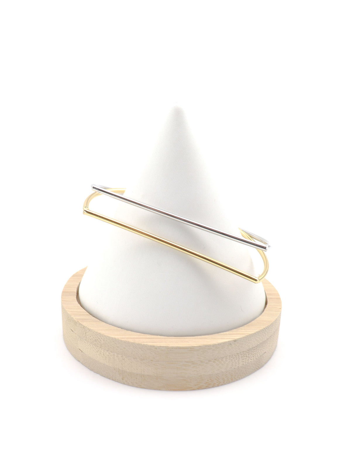 Anito minimalist D-shaped bangles in gold and silver tones displayed on a white jewelry stand.