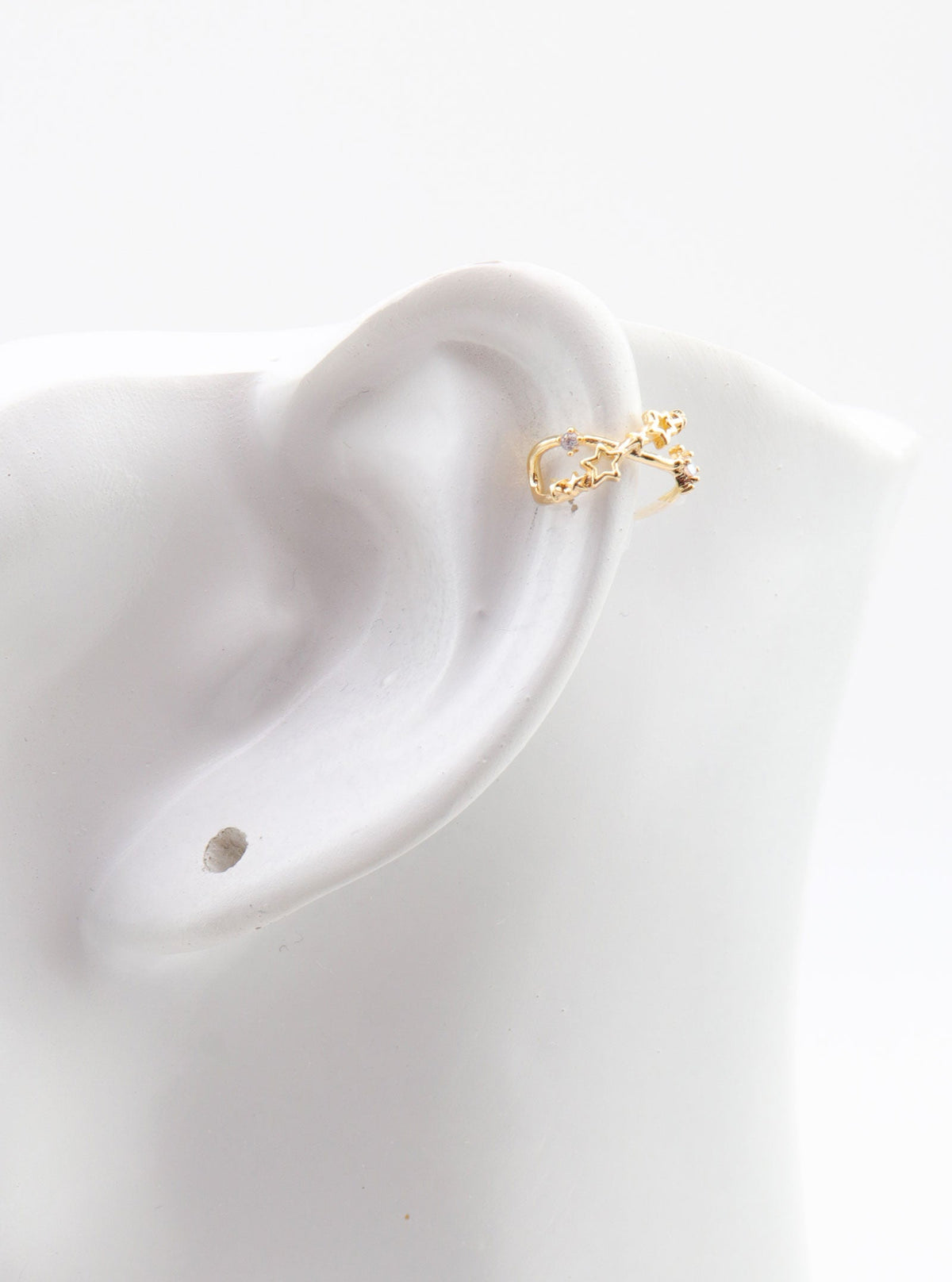 Tanvi gold star ear cuff shown on an ear display