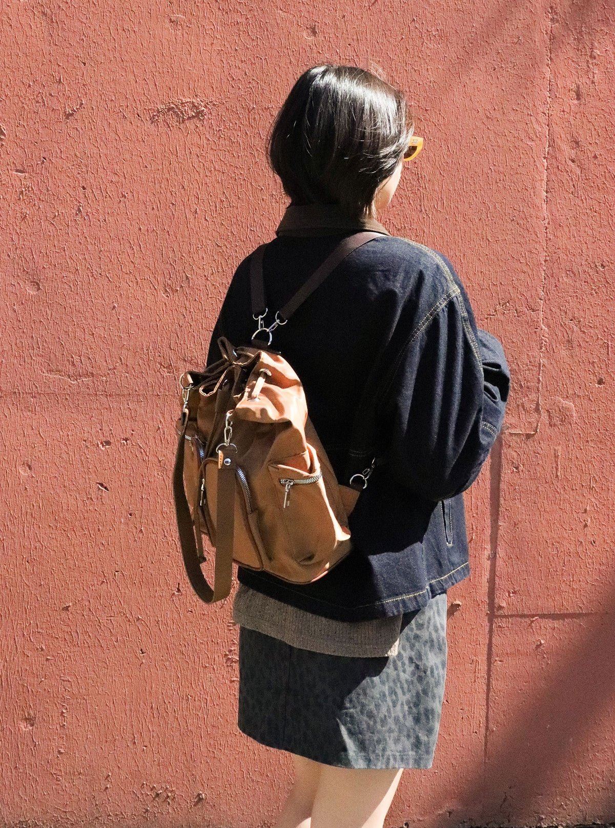Model wearing Brettnie caramel convertible backpack