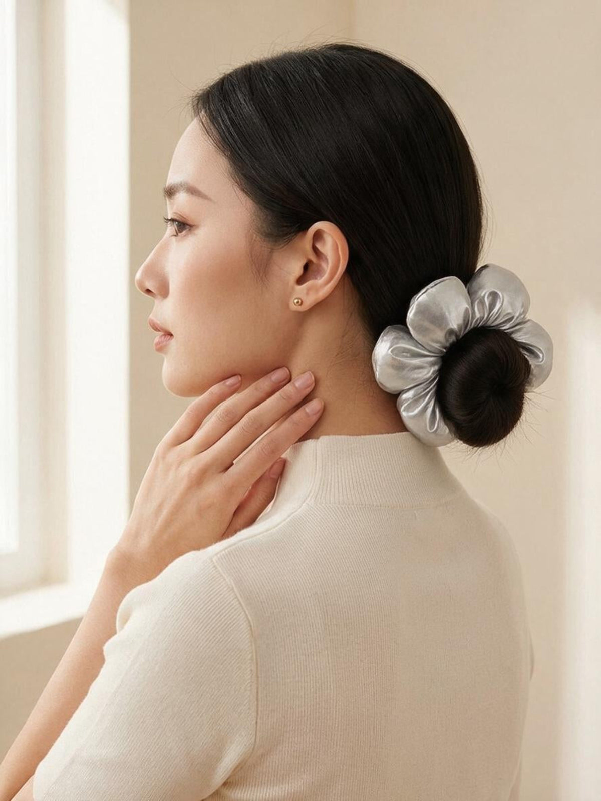 Model wearing Jayva Silver flower scrunchy around a low bun