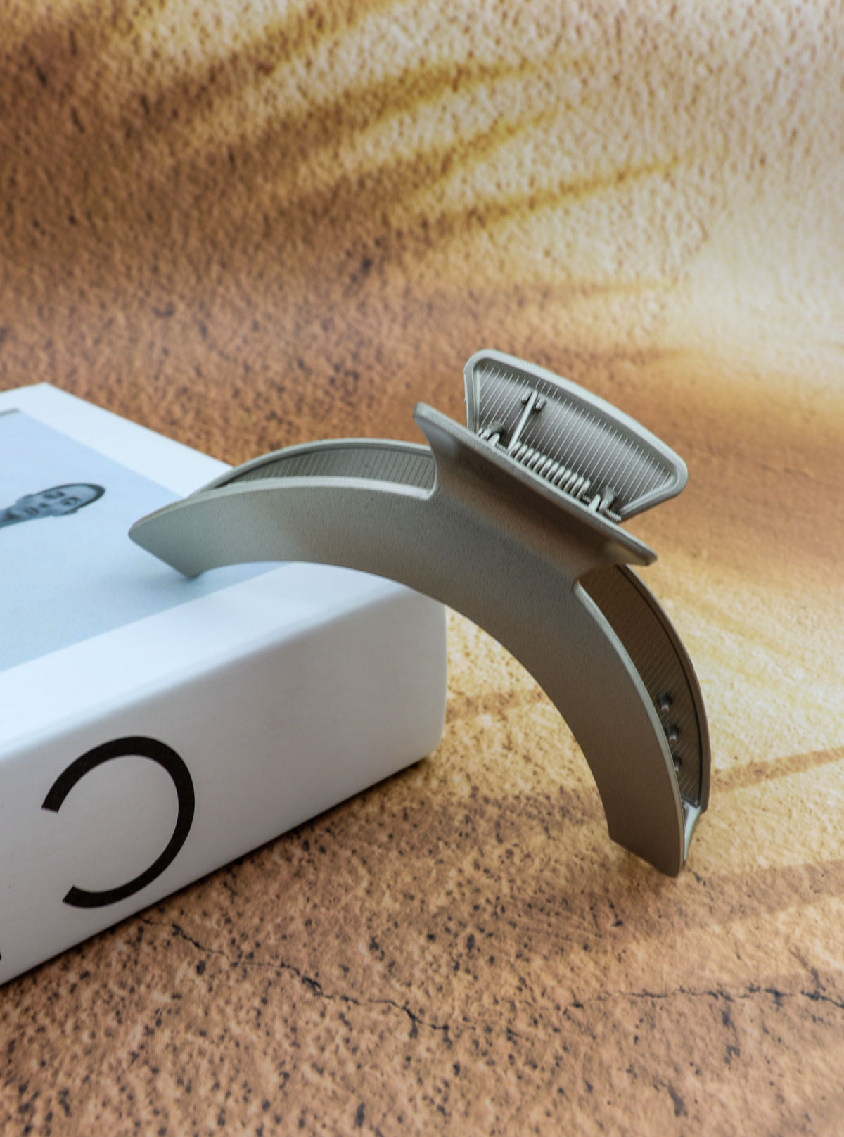 Jila matte silver sculptural hair claw in a styled setting