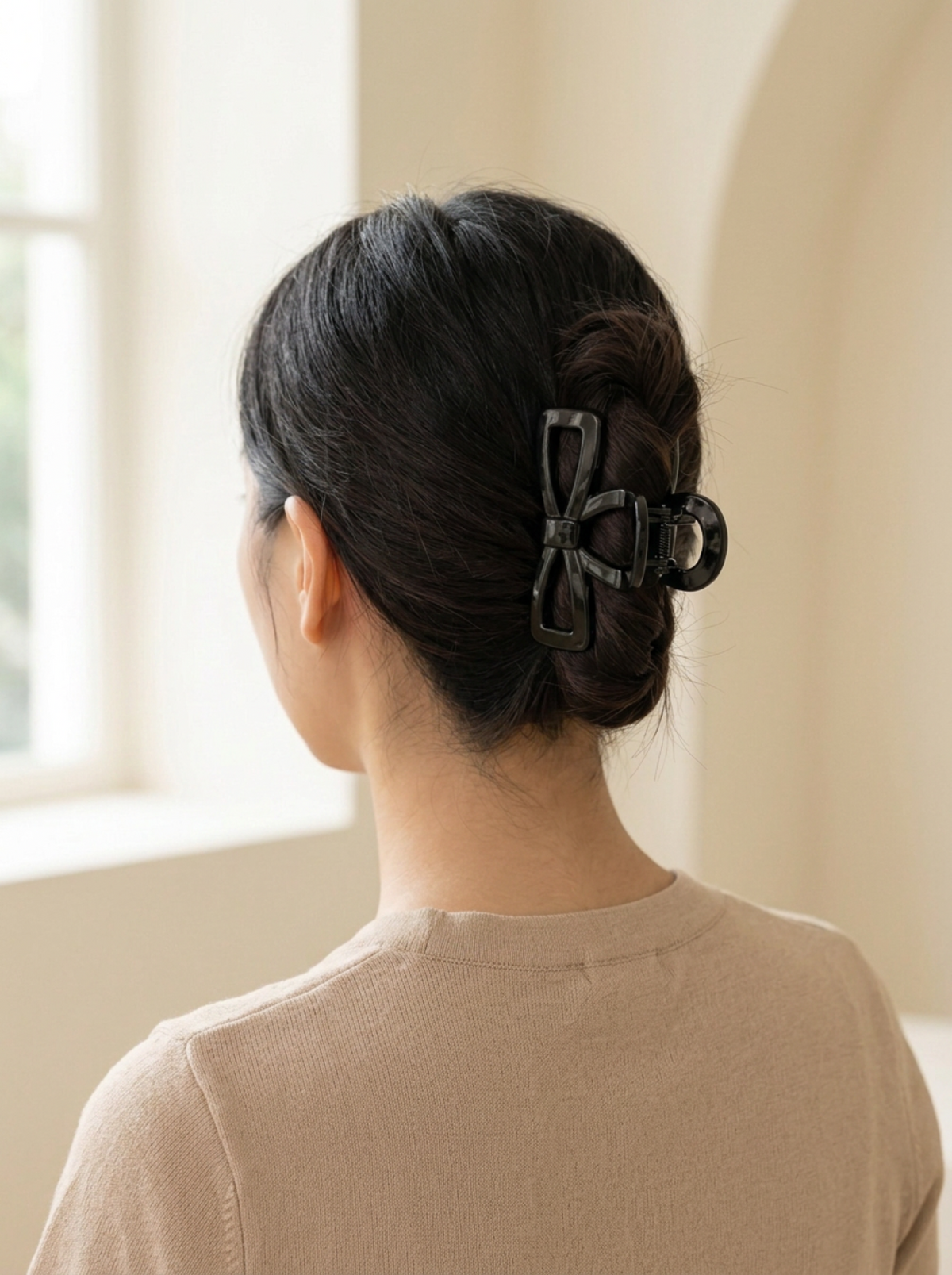Model wearing Jolla black bow hair claw in an updo