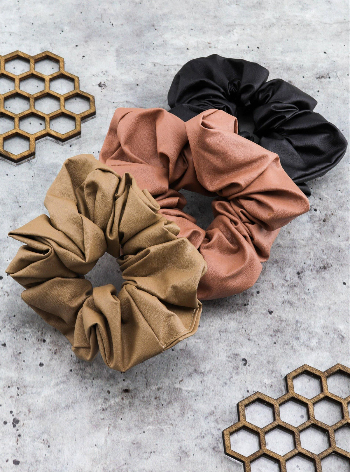 Jiselle faux leather scrunchies in a styled setting